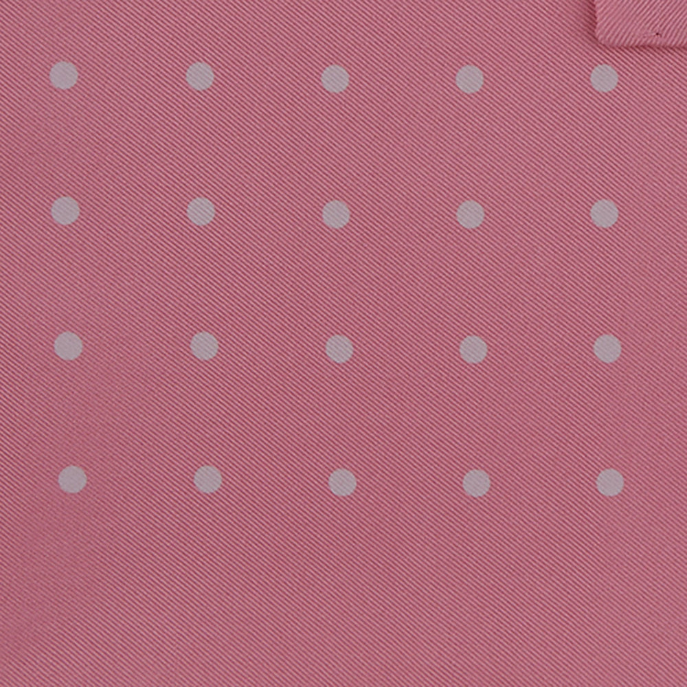 The Rose and White Spot Silk Pocket Square by Turnbull & Asser features rose pink silk with white polka dots and Turnbull & Asser branding in the corner—a refined accessory for any navy suit collection.