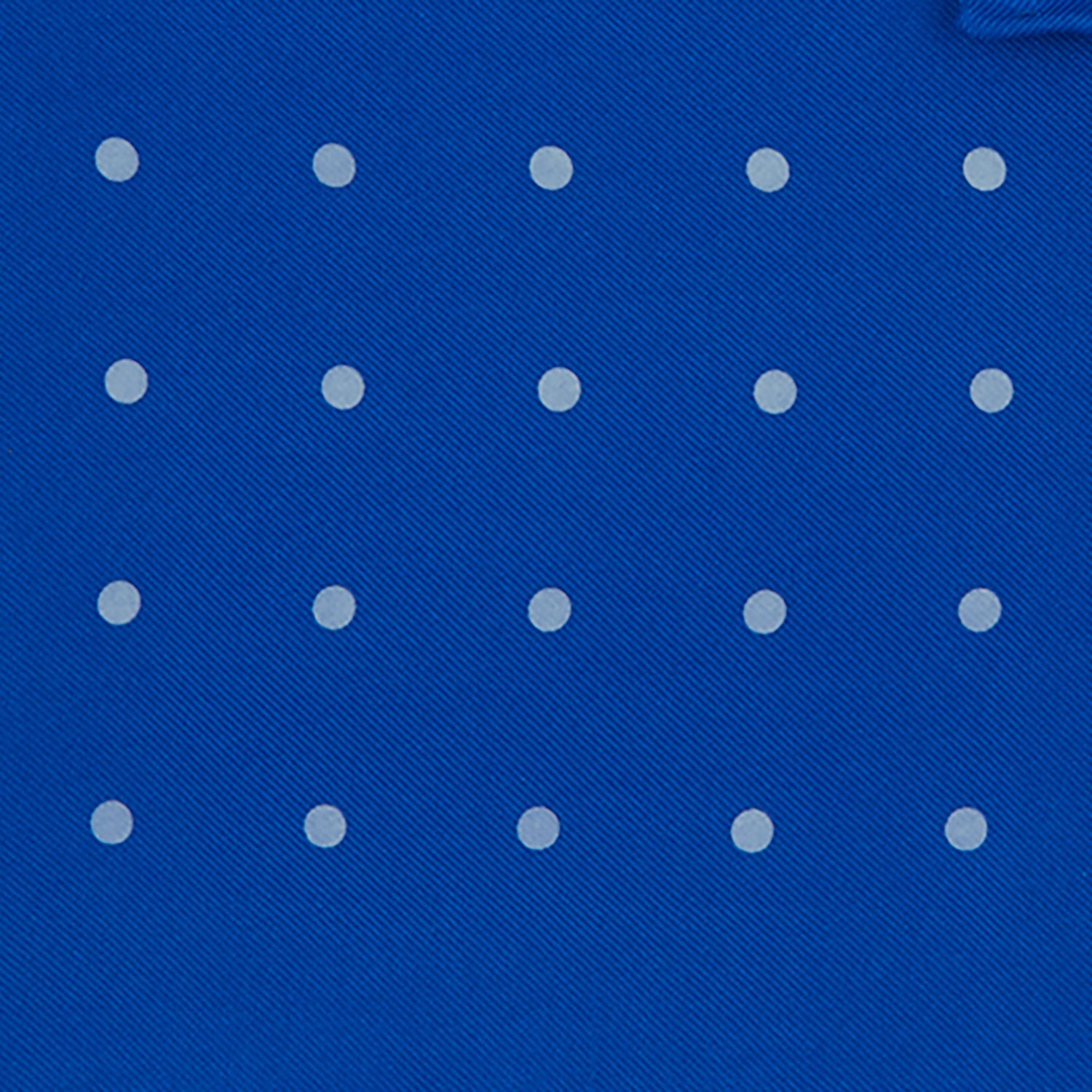 View 3 of product The Royal Blue Spot Silk Pocket Square by Turnbull & Asser features evenly spaced white polka dots and a branded corner, making it the perfect accessory to add flair to pinstripe suits.