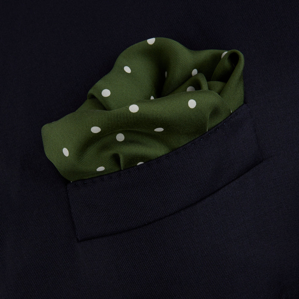 The Turnbull & Asser Olive Spot Silk Pocket Square features white polka dots, the brand’s logo in one corner, and a stylishly folded tip for a dapper finish.