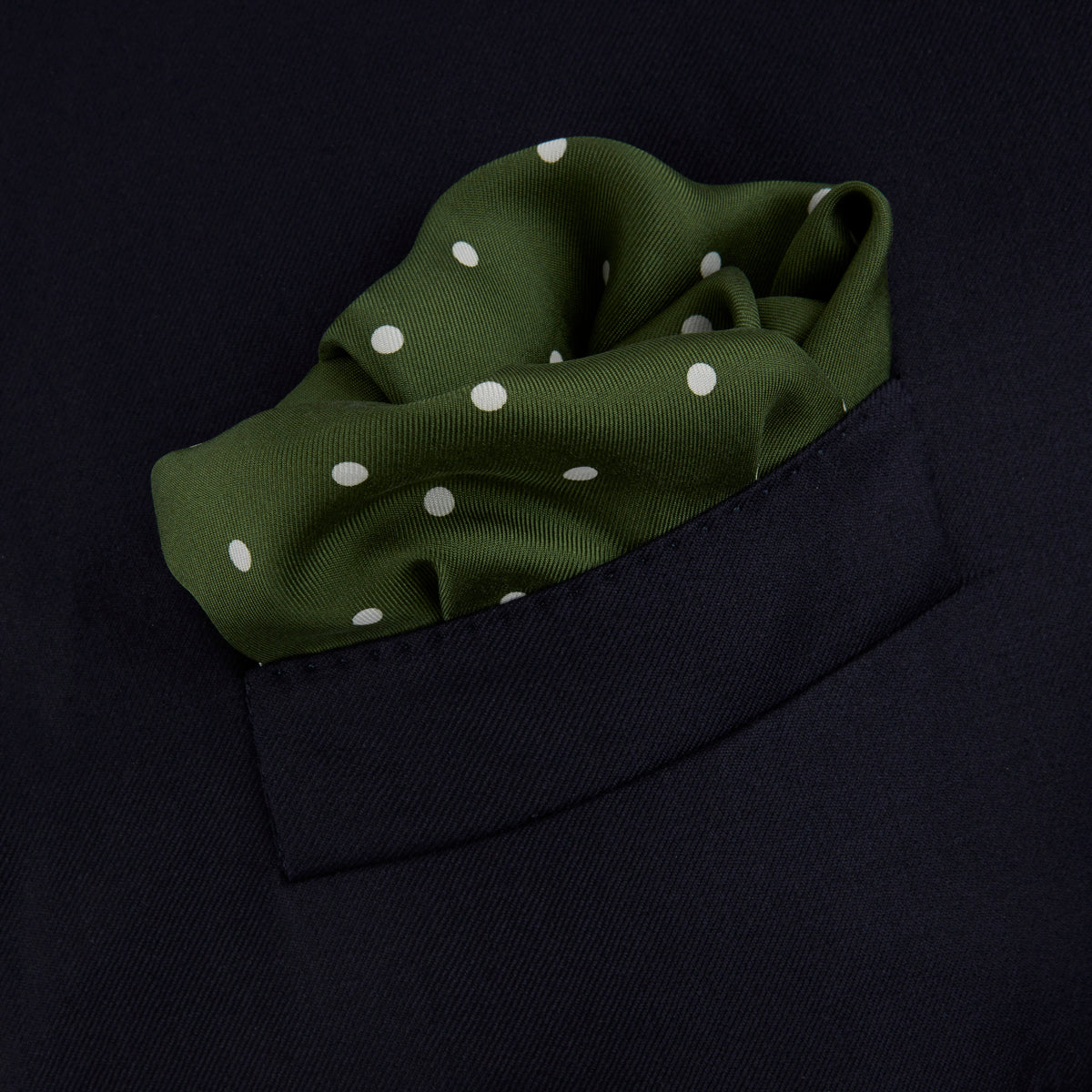 View 4 of product The Turnbull & Asser Olive Spot Silk Pocket Square features white polka dots, the brand’s logo in one corner, and a stylishly folded tip for a dapper finish.