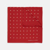 View 1 of product The Red and White Spot Silk Pocket Square by Turnbull & Asser features evenly spaced white polka dots on red silk with the brand's name printed in one corner. A folded edge reveals the reverse of this timeless pocket square.