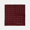 View 1 of product Add a touch of elegance with the Turnbull & Asser Burgundy Spot Silk Pocket Square, featuring white dots, a printed corner logo, and folded edging—a classic men’s accessory for any occasion.