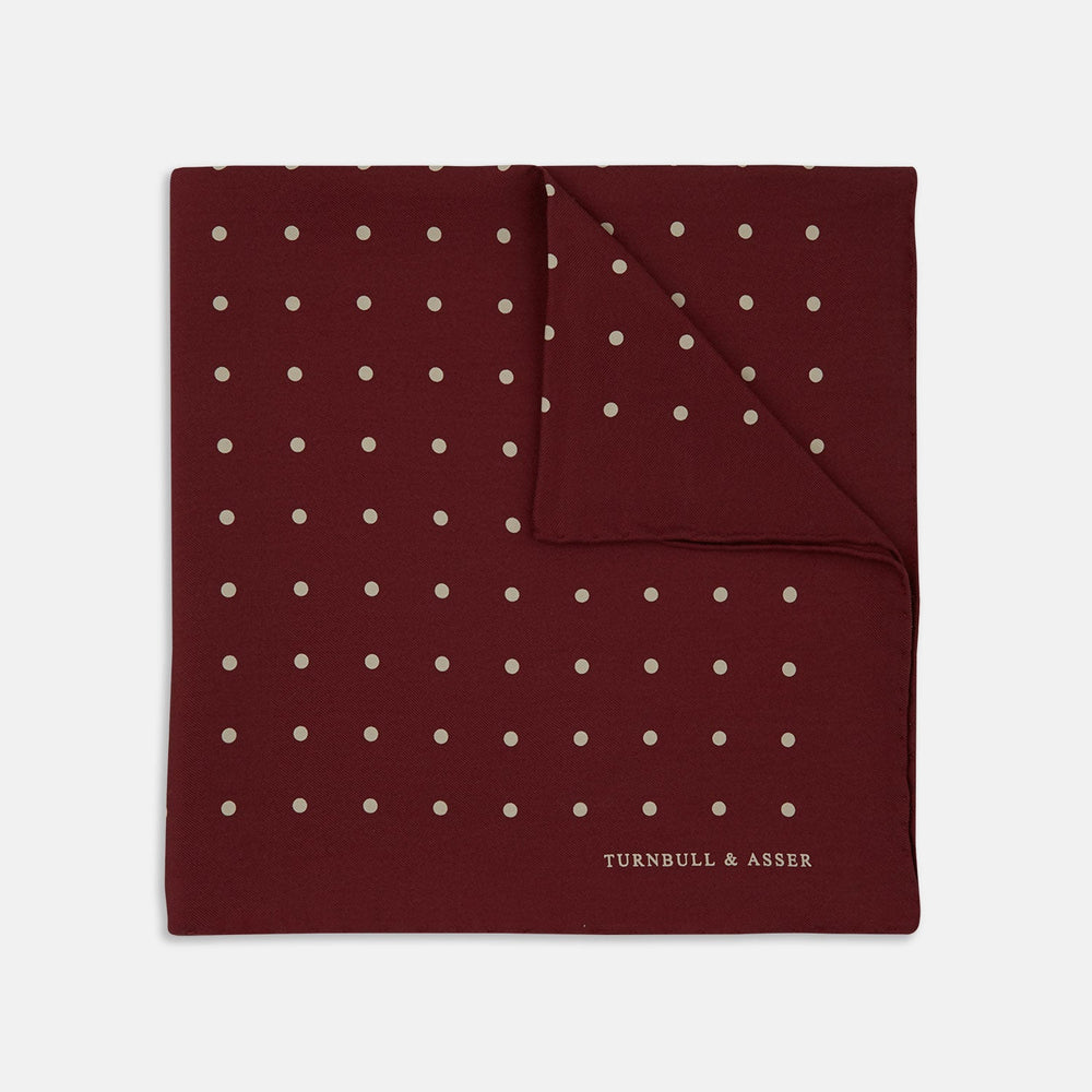 Add a touch of elegance with the Turnbull & Asser Burgundy Spot Silk Pocket Square, featuring white dots, a printed corner logo, and folded edging—a classic men’s accessory for any occasion.