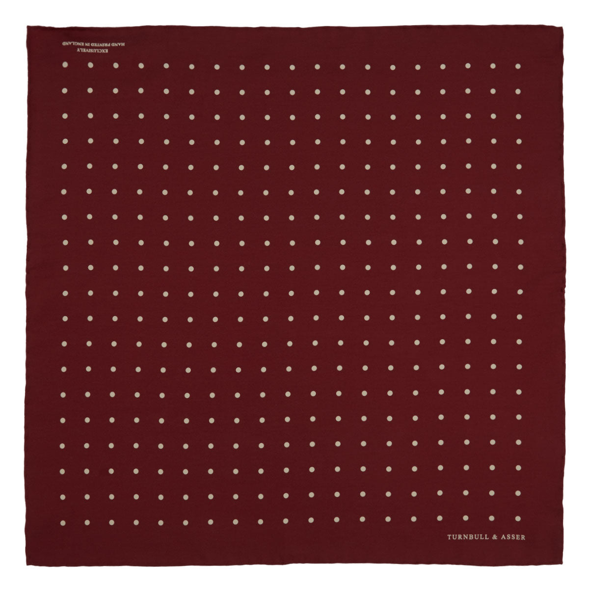 View 2 of product Add a touch of elegance with the Turnbull & Asser Burgundy Spot Silk Pocket Square, featuring white dots, a printed corner logo, and folded edging—a classic men’s accessory for any occasion.