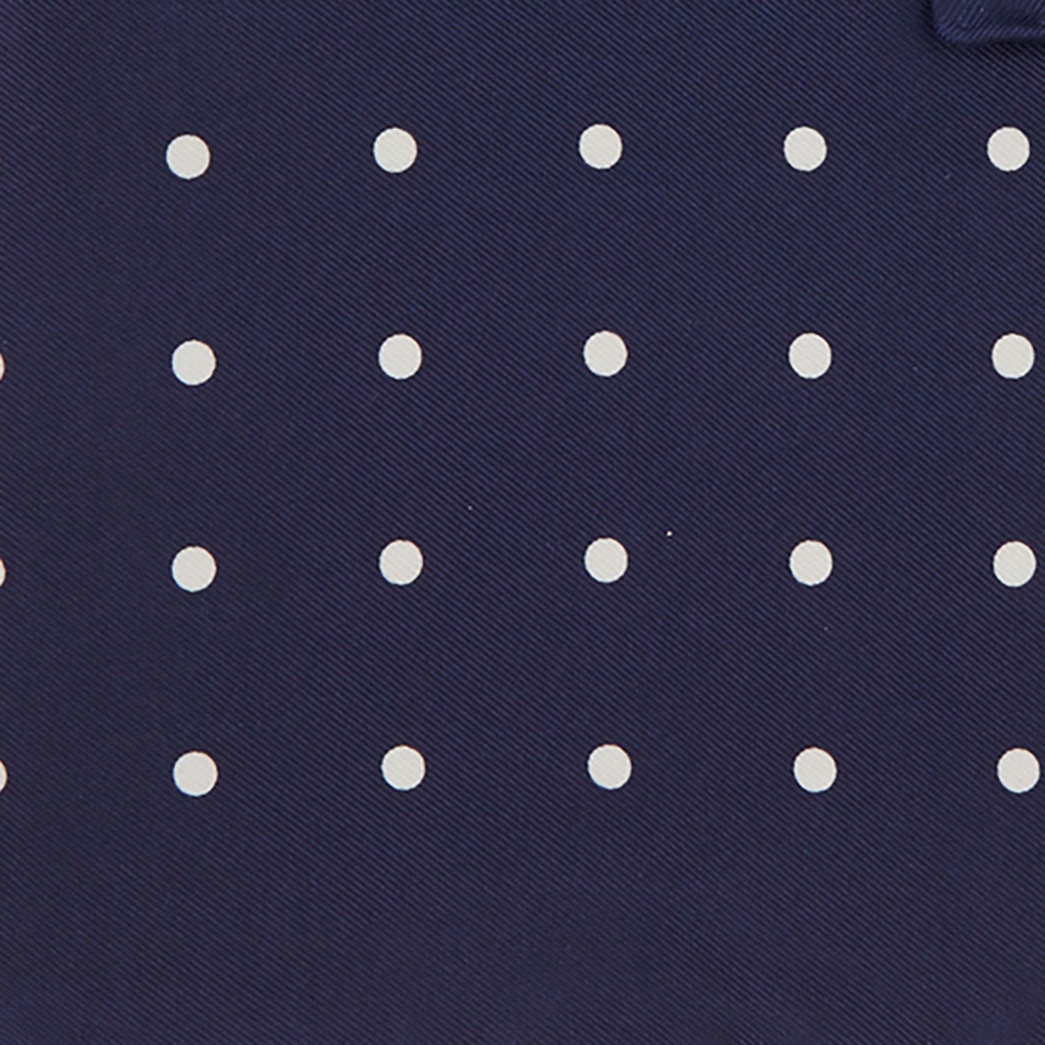 View 3 of product The Navy Spot Silk Pocket Square by Turnbull & Asser features a white polka dot pattern and is neatly folded at one corner, with the brand name printed in white on the lower right—perfect for pairing with pinstripe suits.
