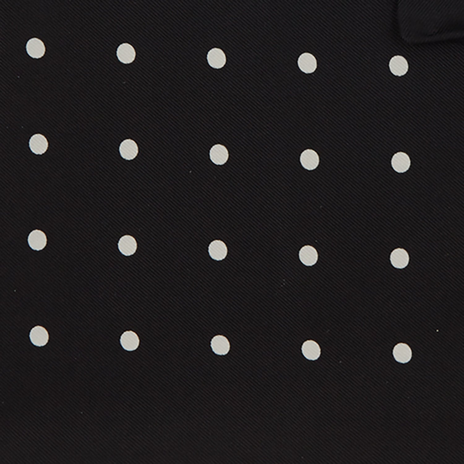 View 3 of product The Black Spot Silk Pocket Square by Turnbull & Asser features classic white polka dots on black silk, with the brand name printed in one corner and a stylish folded design.