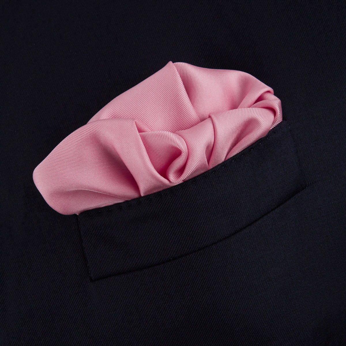 View 4 of product The Pink and White Piped Silk Pocket Square by Turnbull & Asser, featuring the brand’s name in white on one corner, is elegantly folded and set against a plain white background.