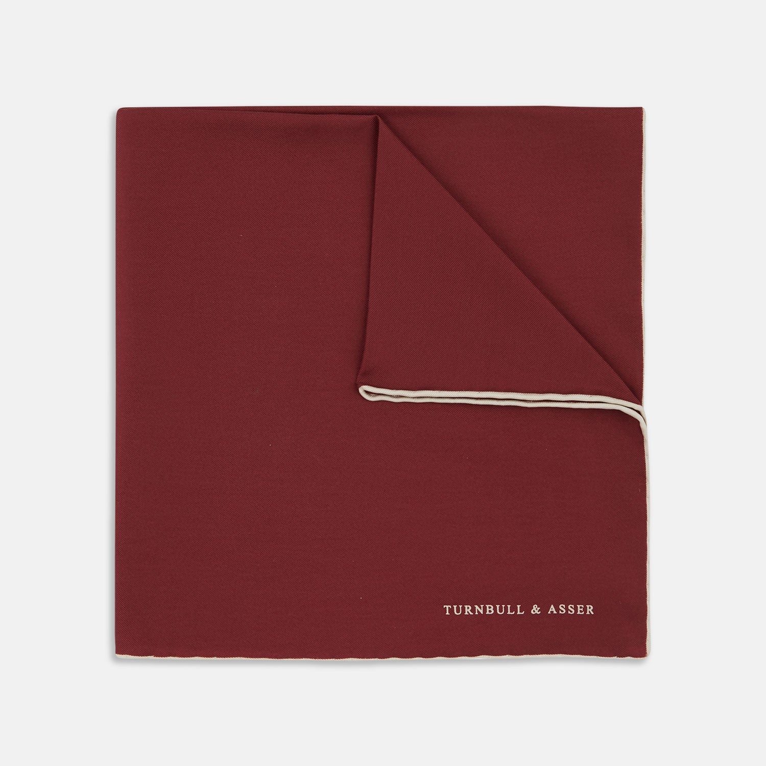 View 1 of product The Turnbull & Asser Burgundy and White Piped Silk Pocket Square features a classic burgundy design with a subtle white piped edge and the brand's logo printed in white on the bottom right corner.