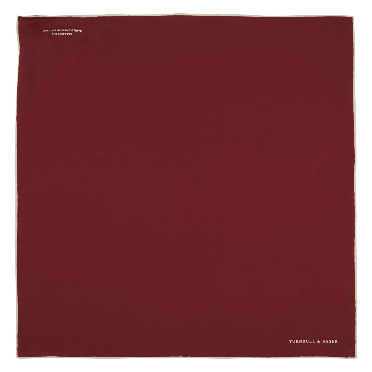 View 2 of product The Turnbull & Asser Burgundy and White Piped Silk Pocket Square features a classic burgundy design with a subtle white piped edge and the brand's logo printed in white on the bottom right corner.