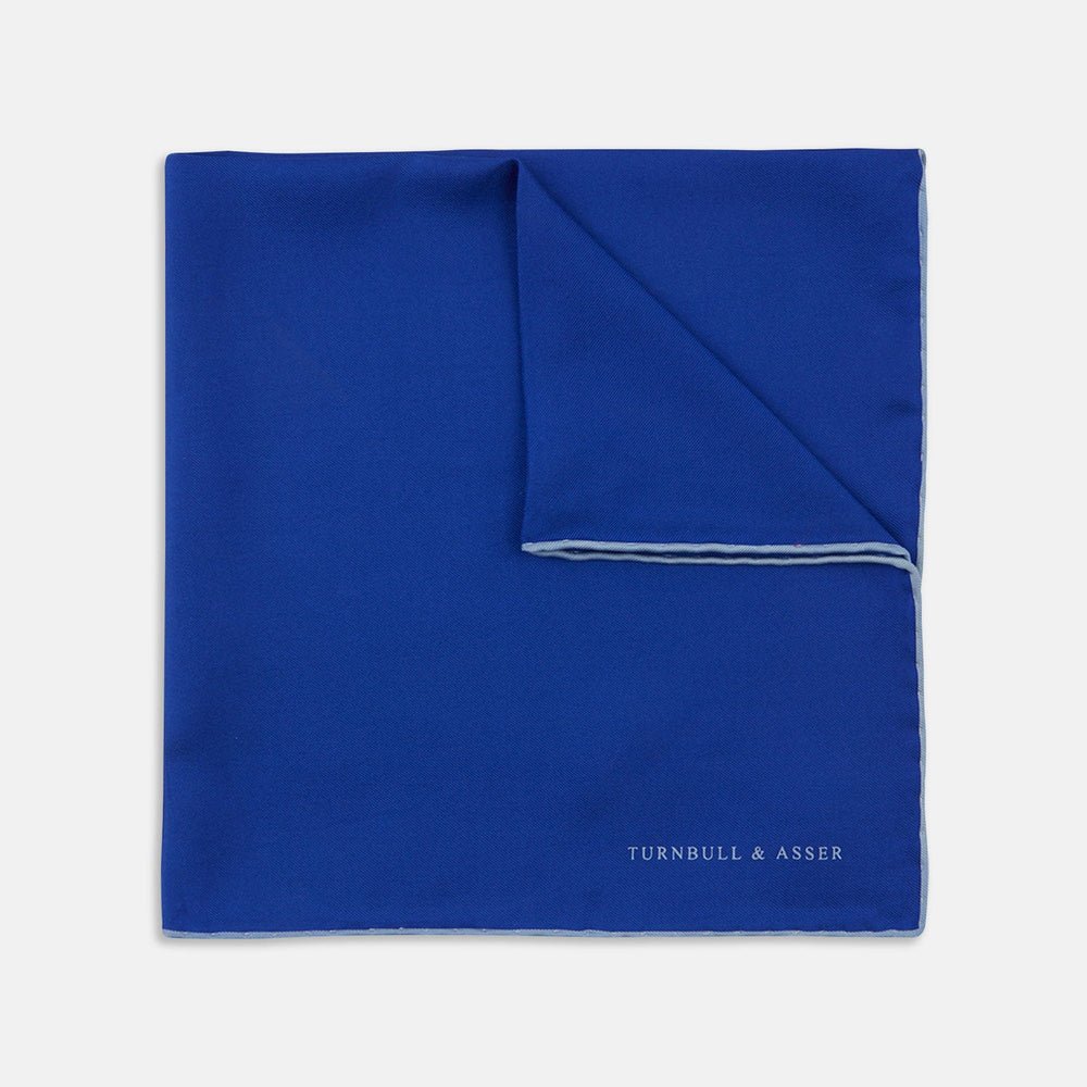 A Dark Blue Piped Silk Pocket Square by Turnbull & Asser, neatly folded with white edging and the brand's logo in one corner, displayed on a plain white background.