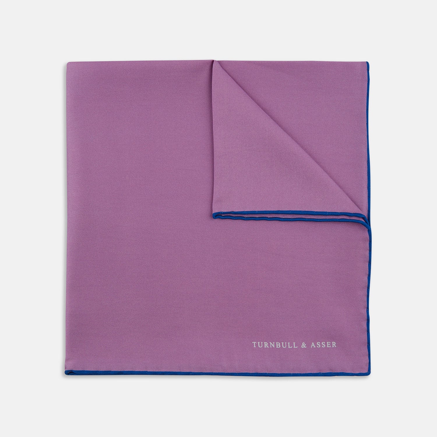 View 1 of product The Lilac and Navy Piped Silk Pocket Square by Turnbull & Asser features a folded lilac design with dark blue trim and the brand's name printed in white in the lower right corner.