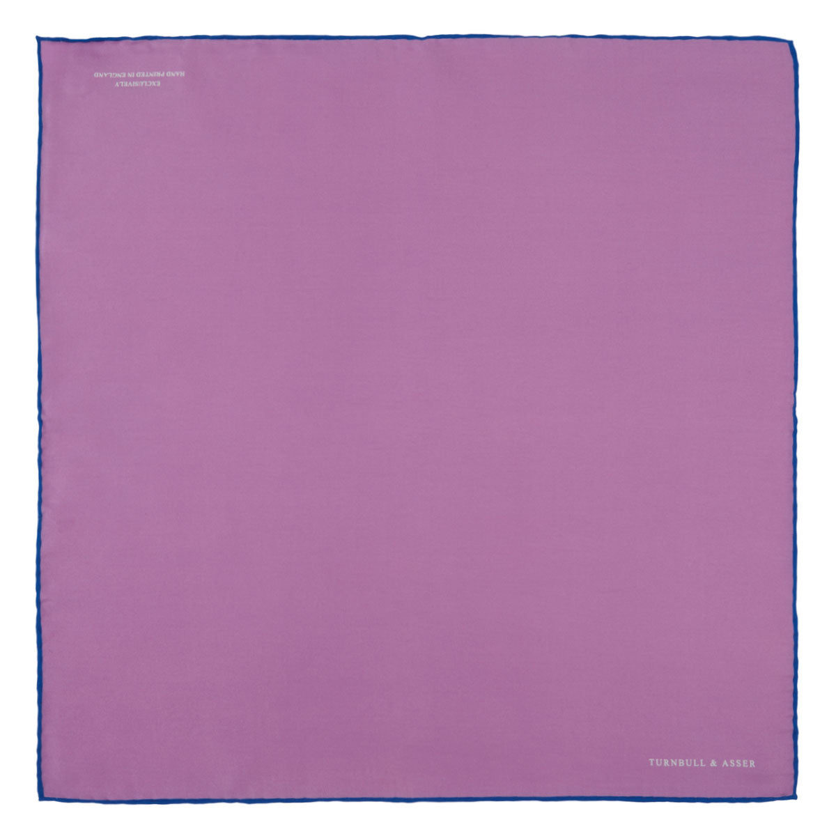 View 2 of product The Lilac and Navy Piped Silk Pocket Square by Turnbull & Asser features a folded lilac design with dark blue trim and the brand's name printed in white in the lower right corner.