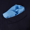 View 4 of product The Light Blue and Navy Piped Silk Pocket Square by Turnbull & Asser, neatly folded with dark blue edges and the brand’s white logo in the corner, is shown on a plain white background—a refined accessory for any occasion.