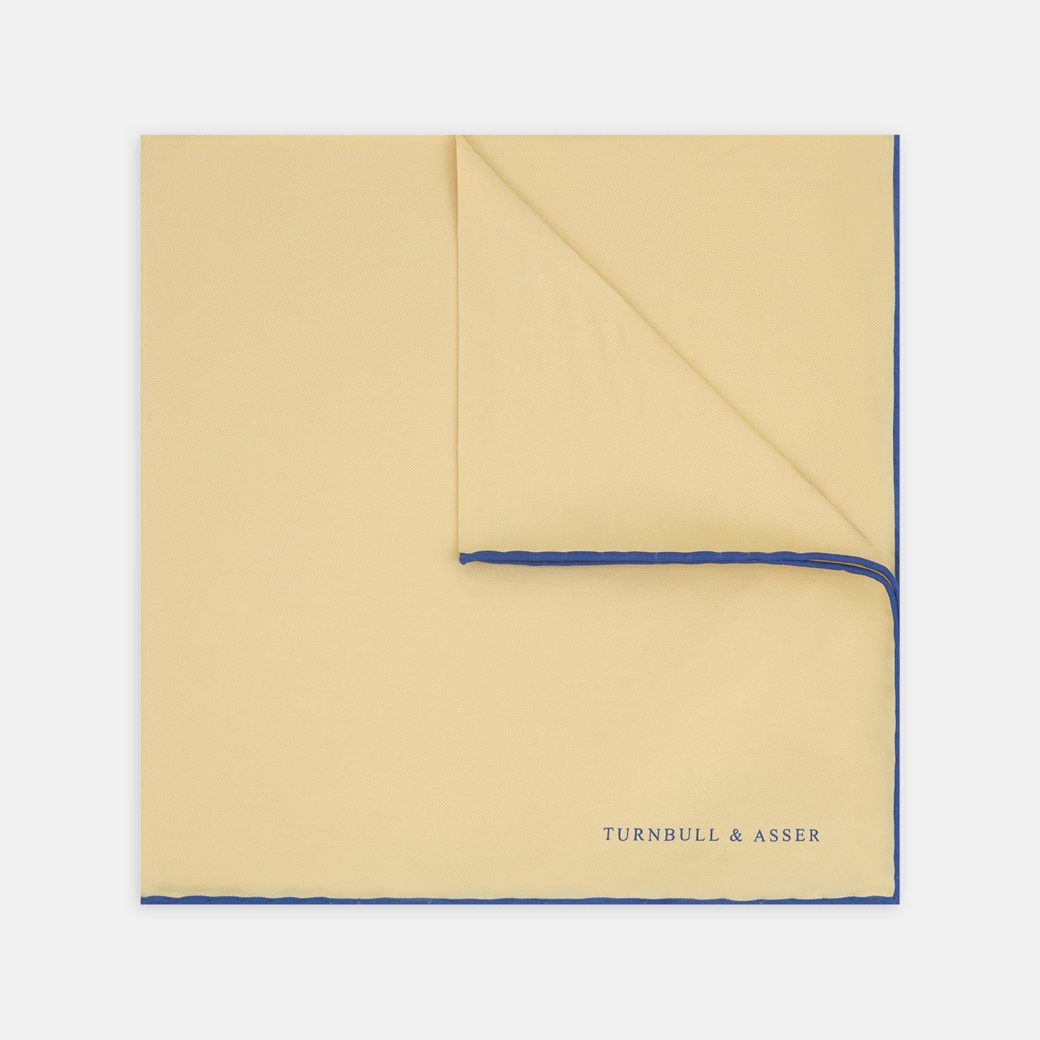View 1 of product The Yellow and Navy Piped Silk Pocket Square by Turnbull & Asser features blue piping and the brand’s logo in blue on yellow silk—an elegant accessory for any outfit.