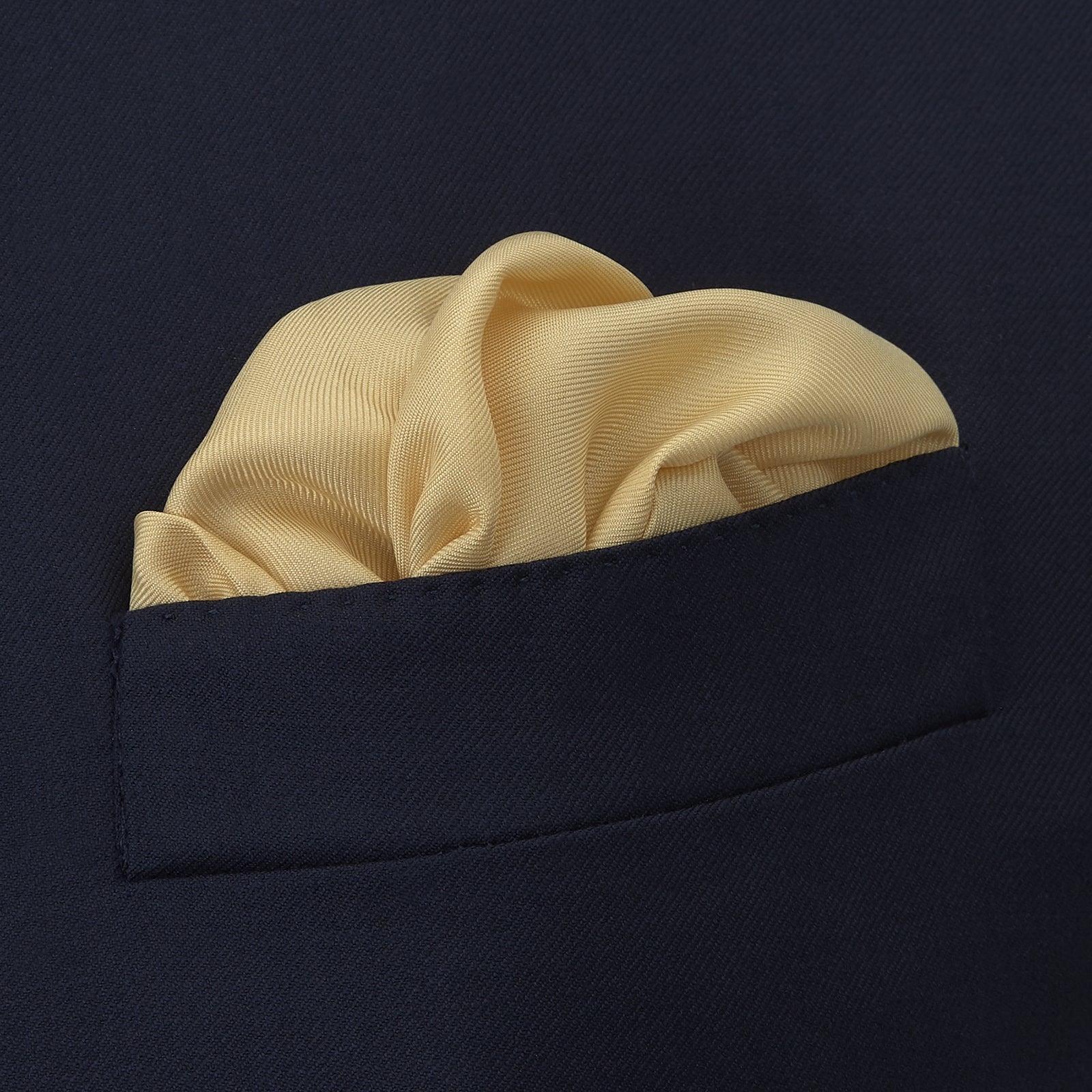 View 4 of product The Yellow and Navy Piped Silk Pocket Square by Turnbull & Asser features blue piping and the brand’s logo in blue on yellow silk—an elegant accessory for any outfit.
