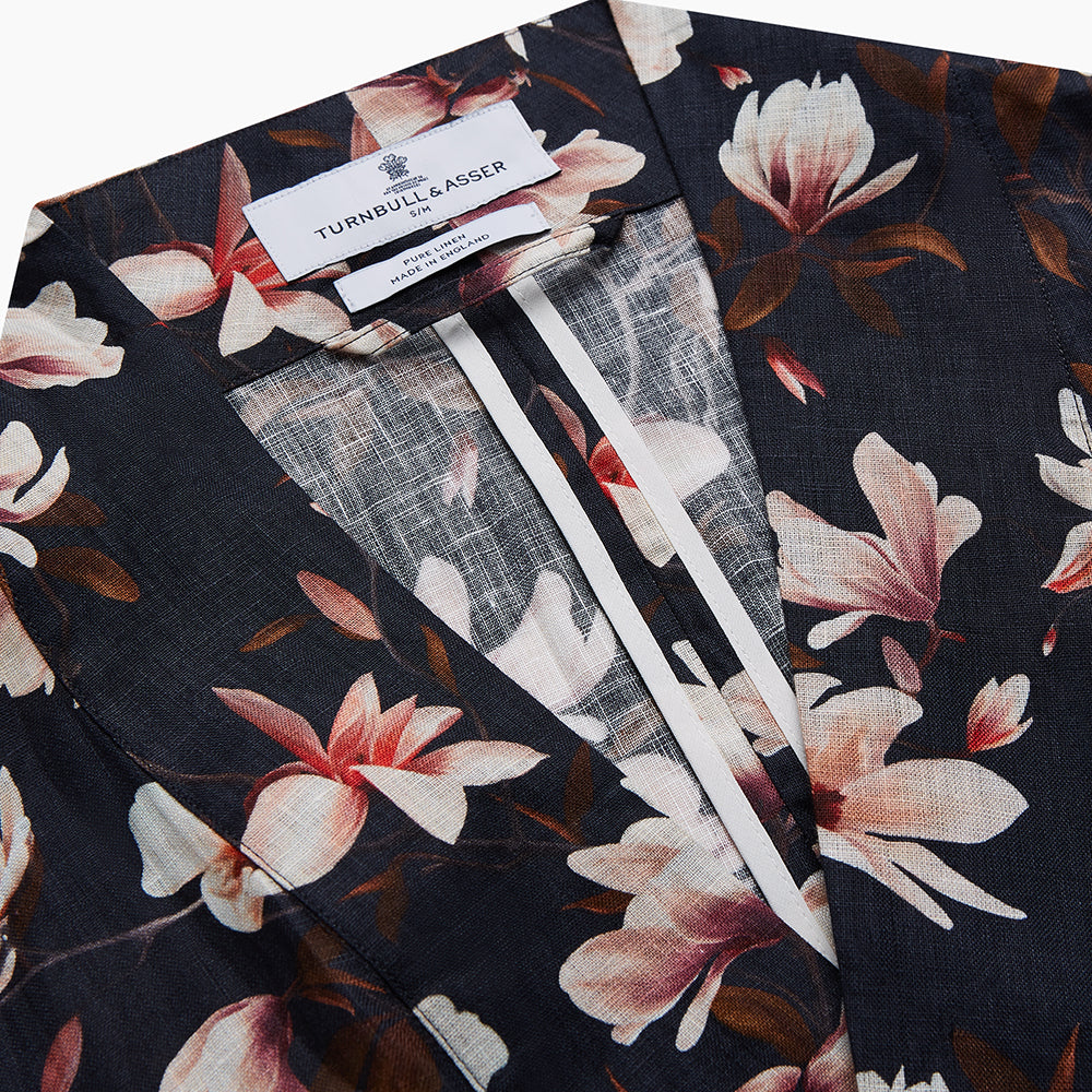 The Turnbull & Asser Navy Floral Pattern Linen Hayhurt Kimono Gown is a knee-length, long-sleeved gown with a floral print and a matching fabric belt tied at the waist.