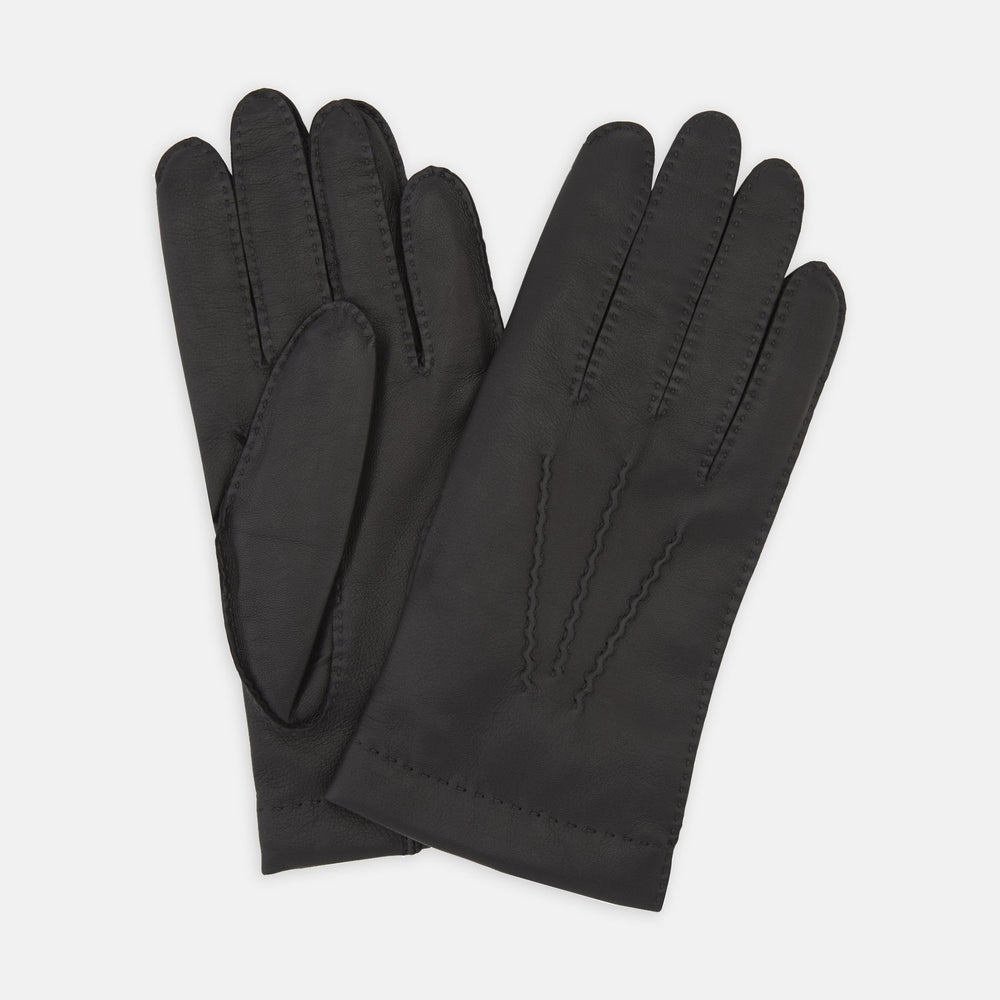 The Walden Black Leather Gloves by Turnbull & Asser, crafted from hairsheep leather with decorative stitching, are shown overlapping on a white background—an elegant showcase of timeless luxury and refined style.