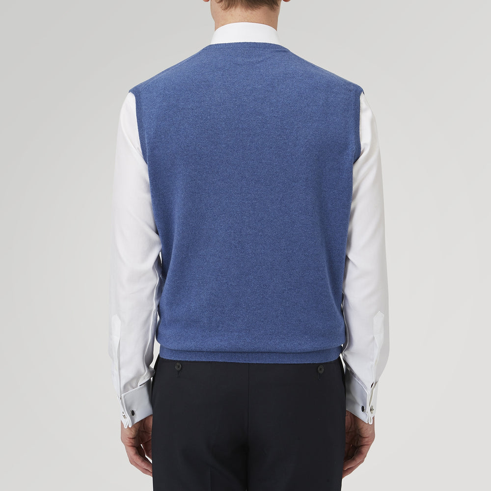 The Turnbull & Asser Blue V-Neck Cashmere Slipover, neatly folded with the label visible, is crafted from soft cashmere and ideal for formal layering. Shown against a white background.