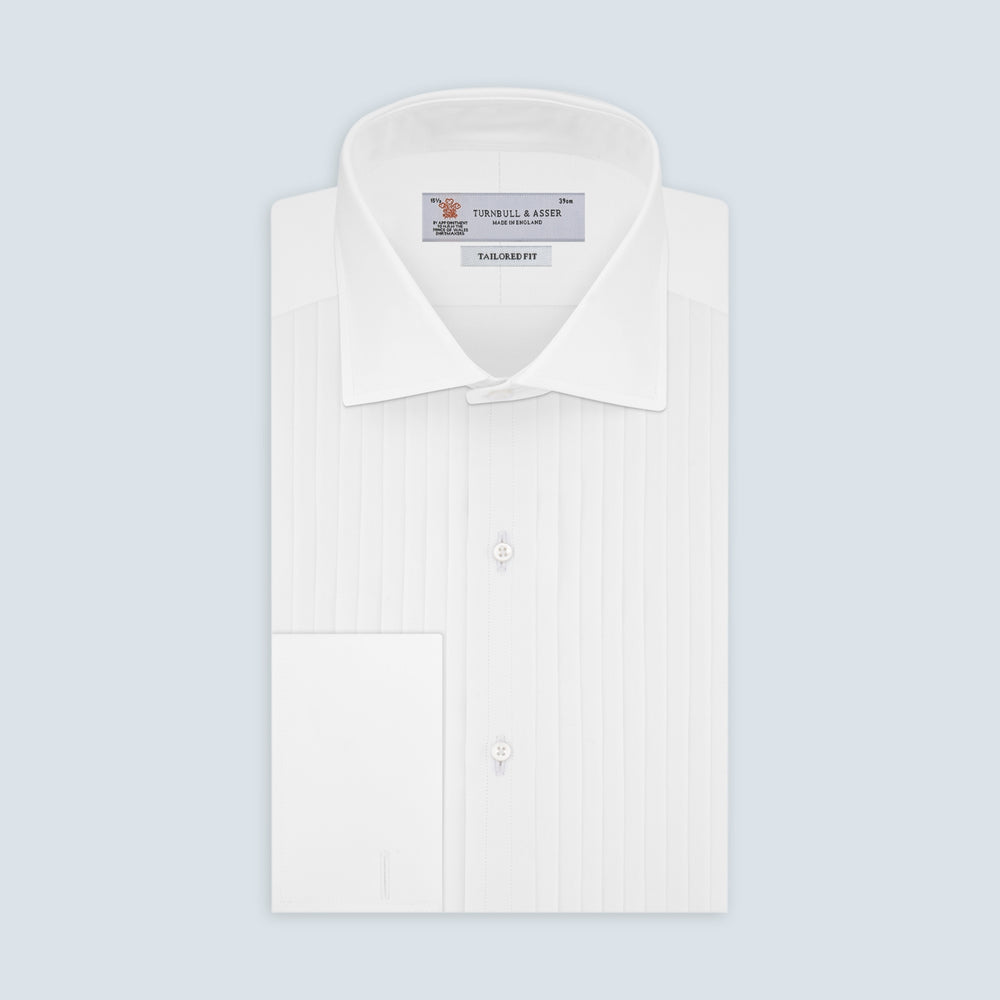 The Tailored Fit White Pleated Front Shirt with Kent Collar and Double Cuffs by Turnbull & Asser is neatly folded and buttoned up, shown on a light grey background—a classic black tie shirt option.