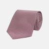 View 1 of product The Turnbull & Asser Dark Pink Houndstooth Silk Tie is rolled up and displayed on a plain white background.