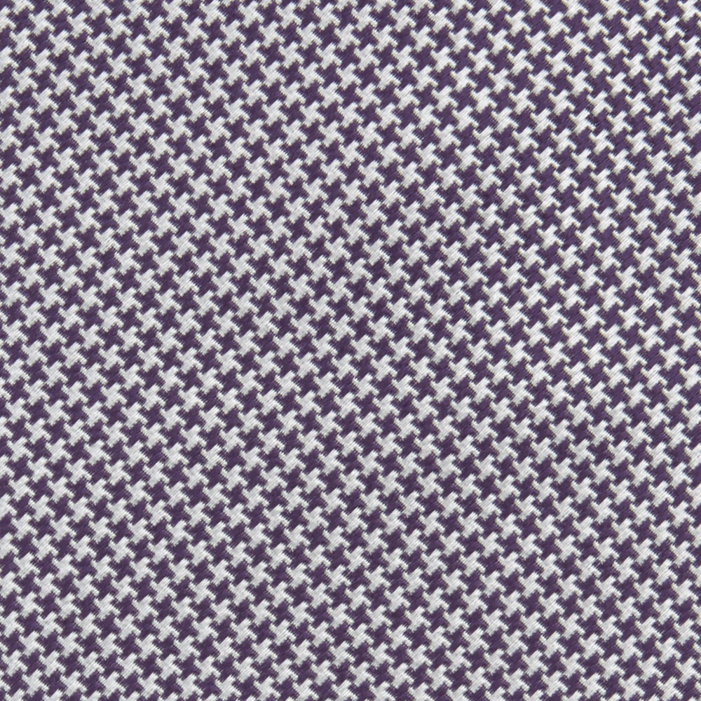 The Plum Houndstooth Silk Tie by Turnbull & Asser features a refined small black, white, and gray pattern—perfect as an office shirt accessory—shown rolled up on a plain white background.