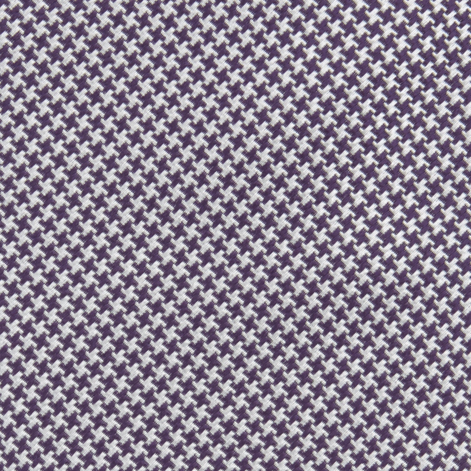 View 3 of product The Plum Houndstooth Silk Tie by Turnbull & Asser features a refined small black, white, and gray pattern—perfect as an office shirt accessory—shown rolled up on a plain white background.