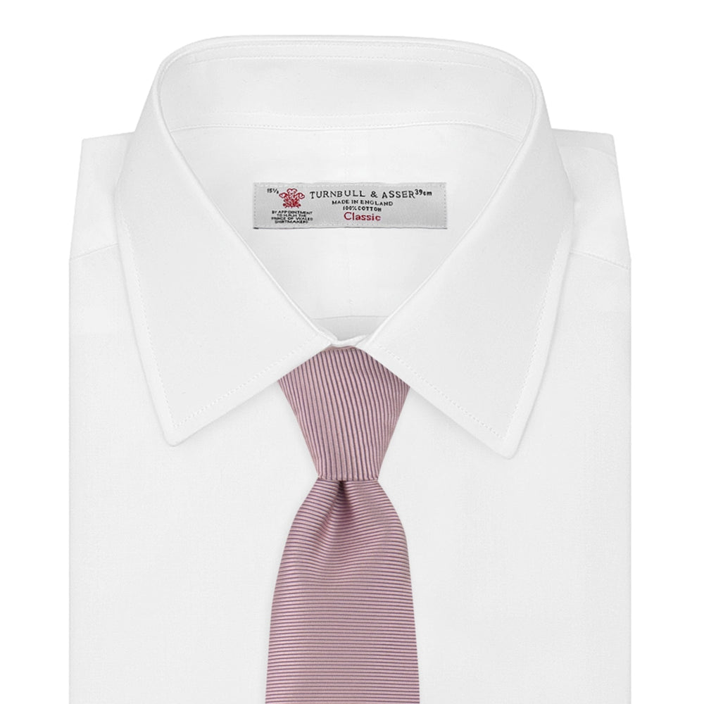 The Turnbull & Asser Rose Horizontal Twill Silk Tie features a pale pink ribbed silk texture, displayed on a white background—ideal for adding a smart touch to cotton shirts.