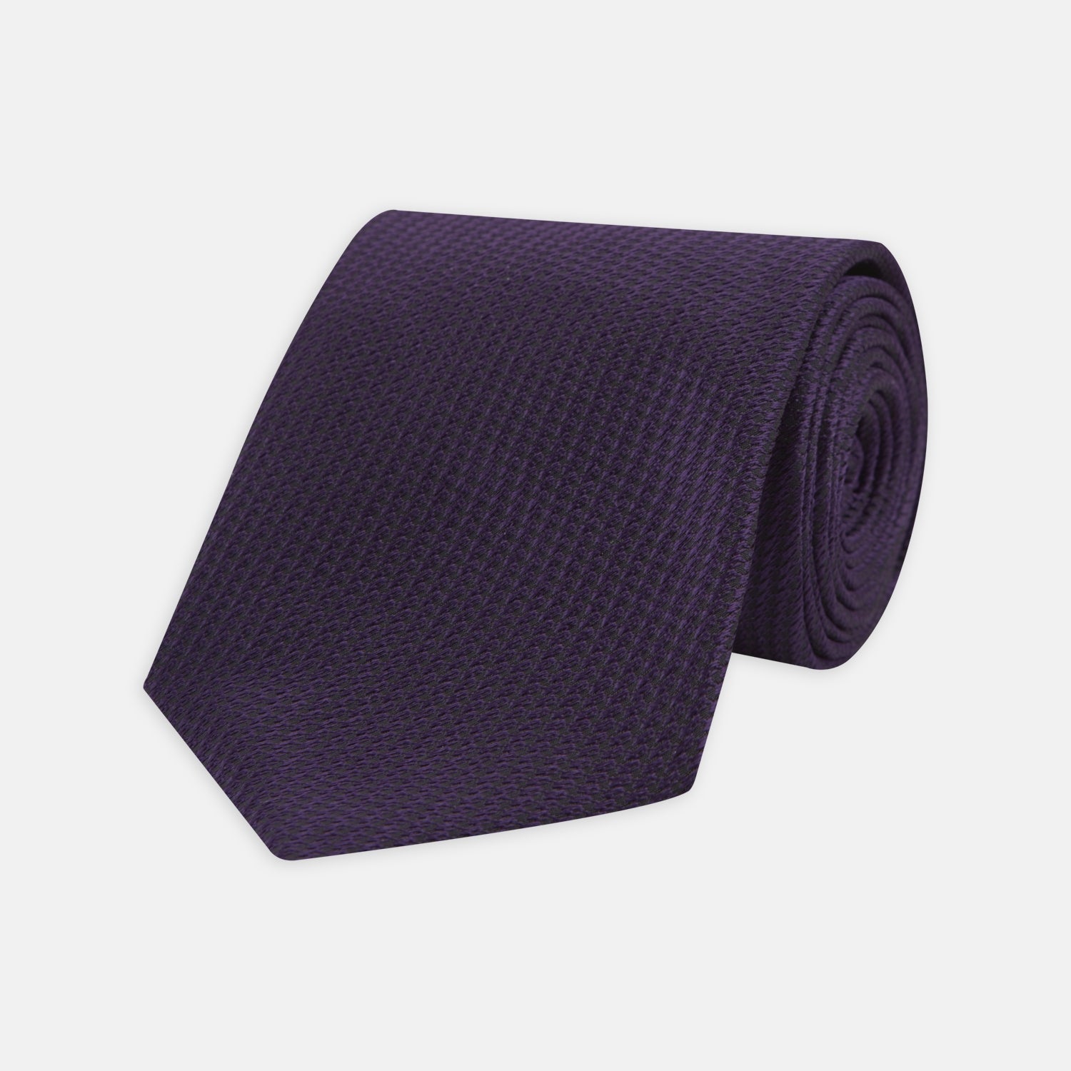 View 1 of product The Turnbull & Asser Plum Lace Silk Tie features a neatly rolled, dark purple design with a textured finish, displayed on a plain white background.