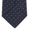 View 4 of product The Turnbull & Asser Navy and Rose Spot Lace Silk Tie features a rolled-up navy design with delicate rose spots, ideal for adding elegance to any office shirt, shown against a plain white background.