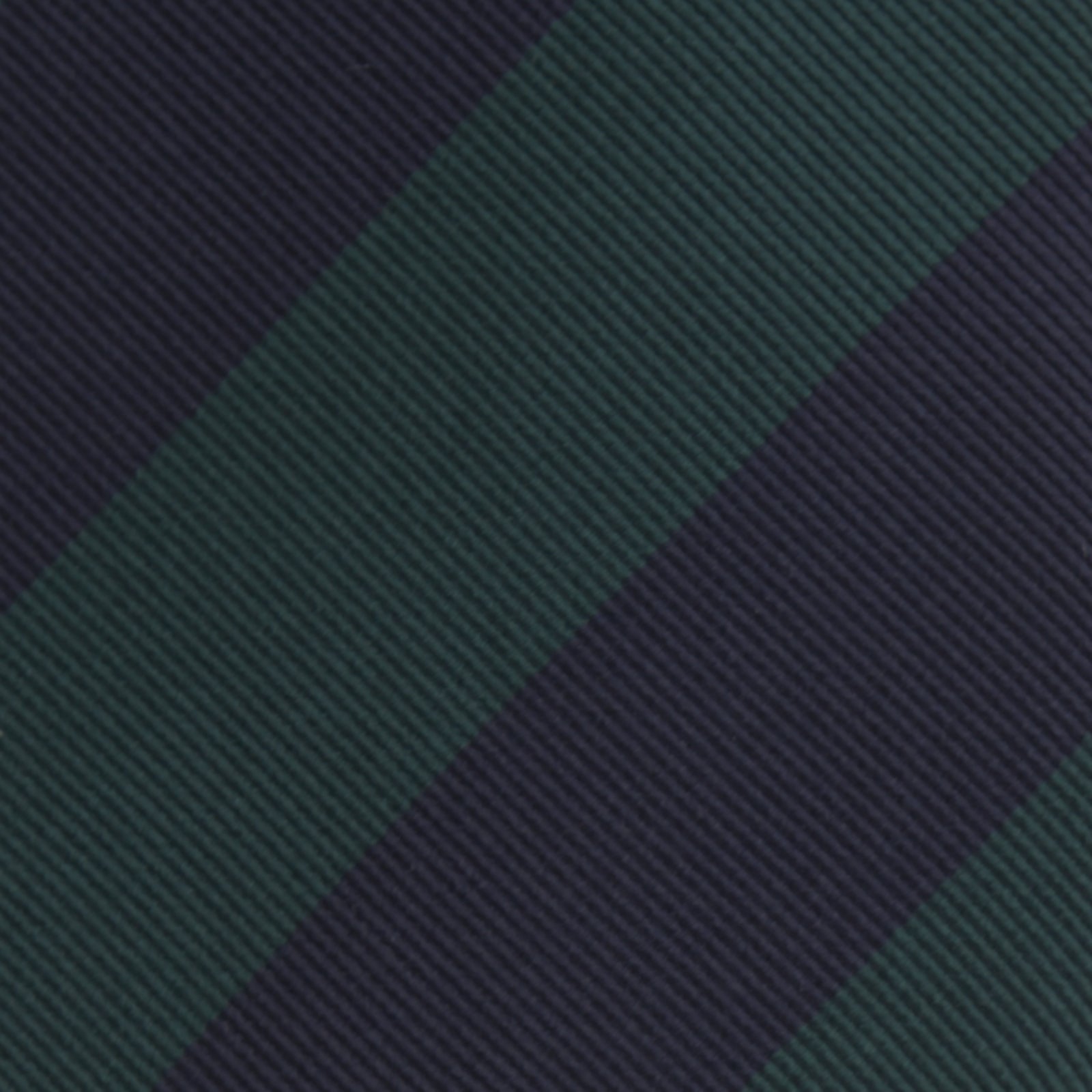 View 3 of product The Turnbull & Asser Navy and Forest Green Block Stripe Repp Silk Tie features bold stripes and is expertly crafted from luxurious silk, shown rolled on a white background.
