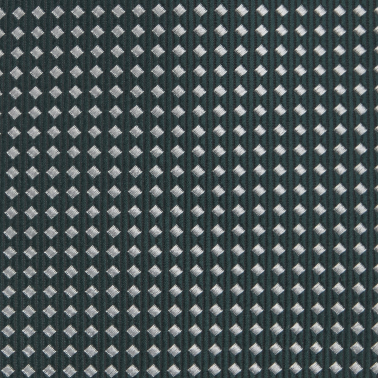 View 3 of product The Turnbull & Asser Forest Green and White Diamond Silk Tie features a geometric pattern of small, evenly spaced white diamonds on a forest green background, displayed rolled up on a white surface.