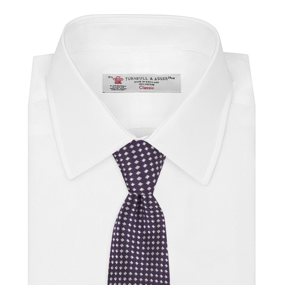 The Turnbull & Asser Plum and White Diamond Silk Tie features a subtle repeating pattern, shown rolled up on a white background—a timeless accessory to elevate any office shirt.