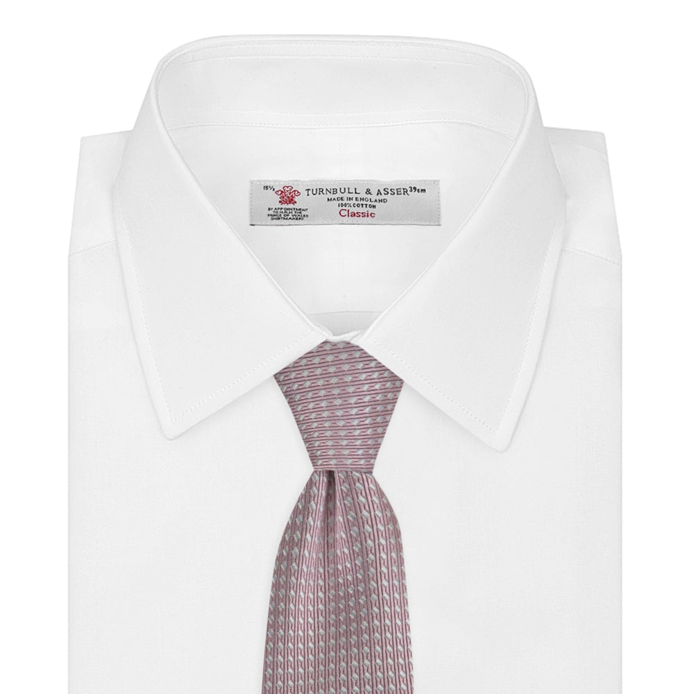 The Turnbull & Asser Rose and White Diamond Silk Tie, shown rolled on a white background, features a subtle diamond pattern—an elegant accessory to elevate any office shirt.