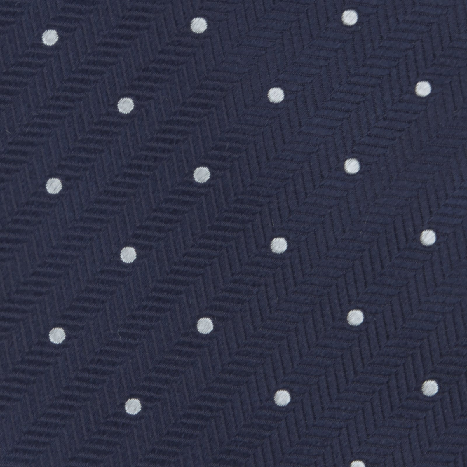 View 3 of product The Navy and White Small Spot Herringbone Silk Tie from Turnbull & Asser features a classic navy herringbone pattern with small white polka dots, offering an elegant look suitable for any occasion.