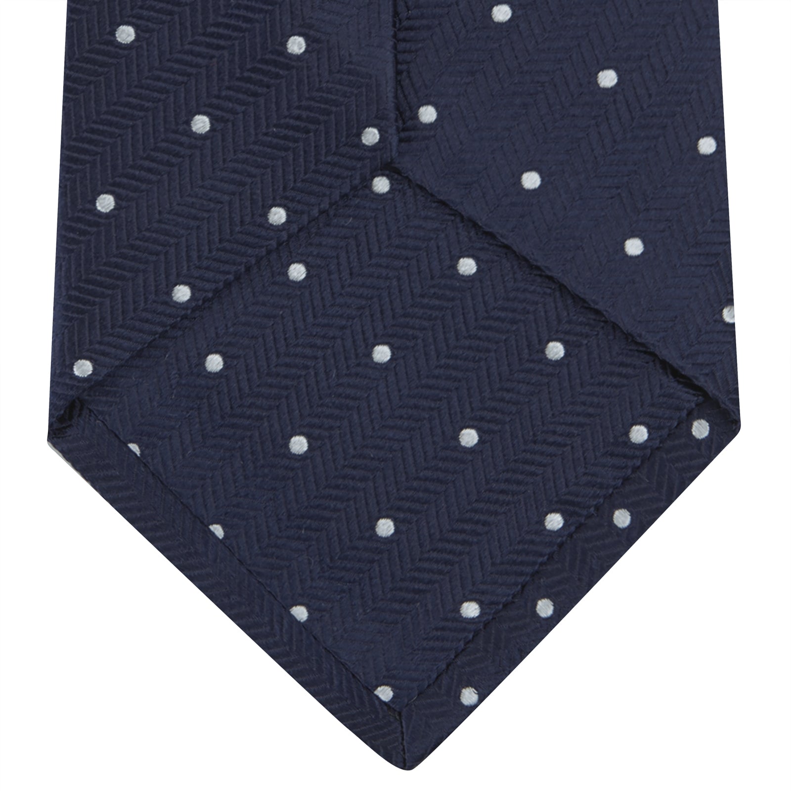 View 4 of product The Navy and White Small Spot Herringbone Silk Tie from Turnbull & Asser features a classic navy herringbone pattern with small white polka dots, offering an elegant look suitable for any occasion.