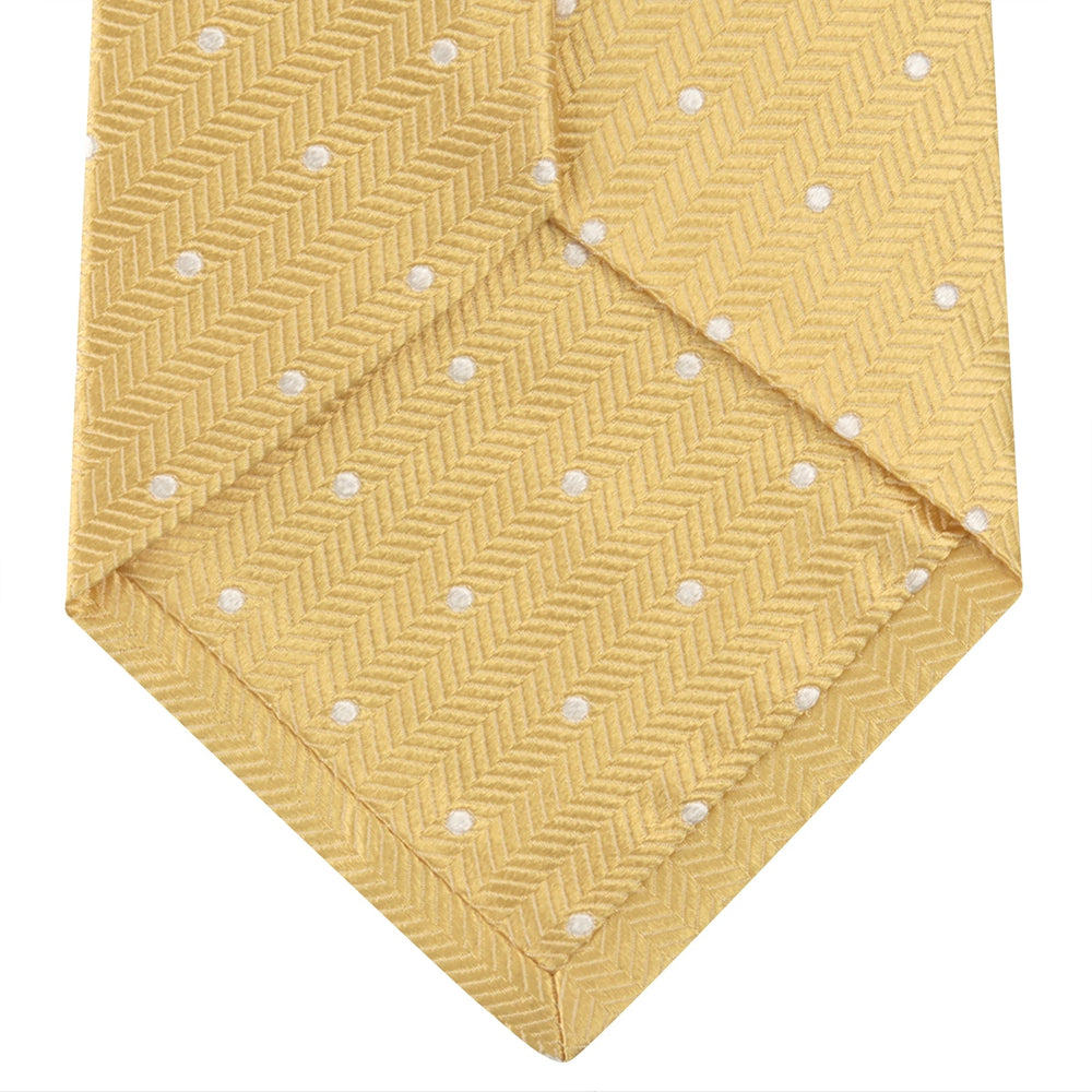 The Turnbull & Asser Gold and White Small Spot Herringbone Silk Tie is crafted from fine English silk, featuring a gold herringbone weave with white polka dots, and is shown rolled up on a white background.