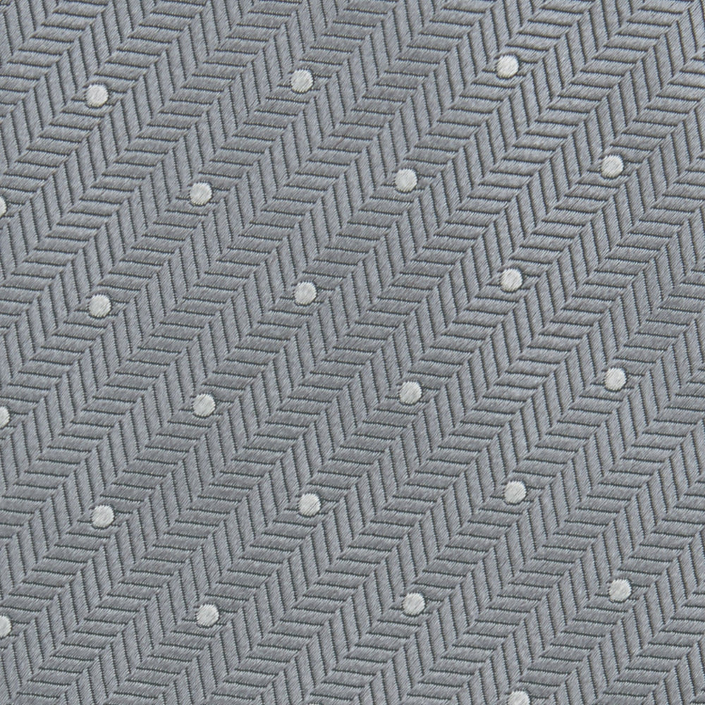 The Turnbull & Asser Grey and White Small Spot Herringbone Silk Tie, expertly woven from silk, is displayed rolled-up against a white background.