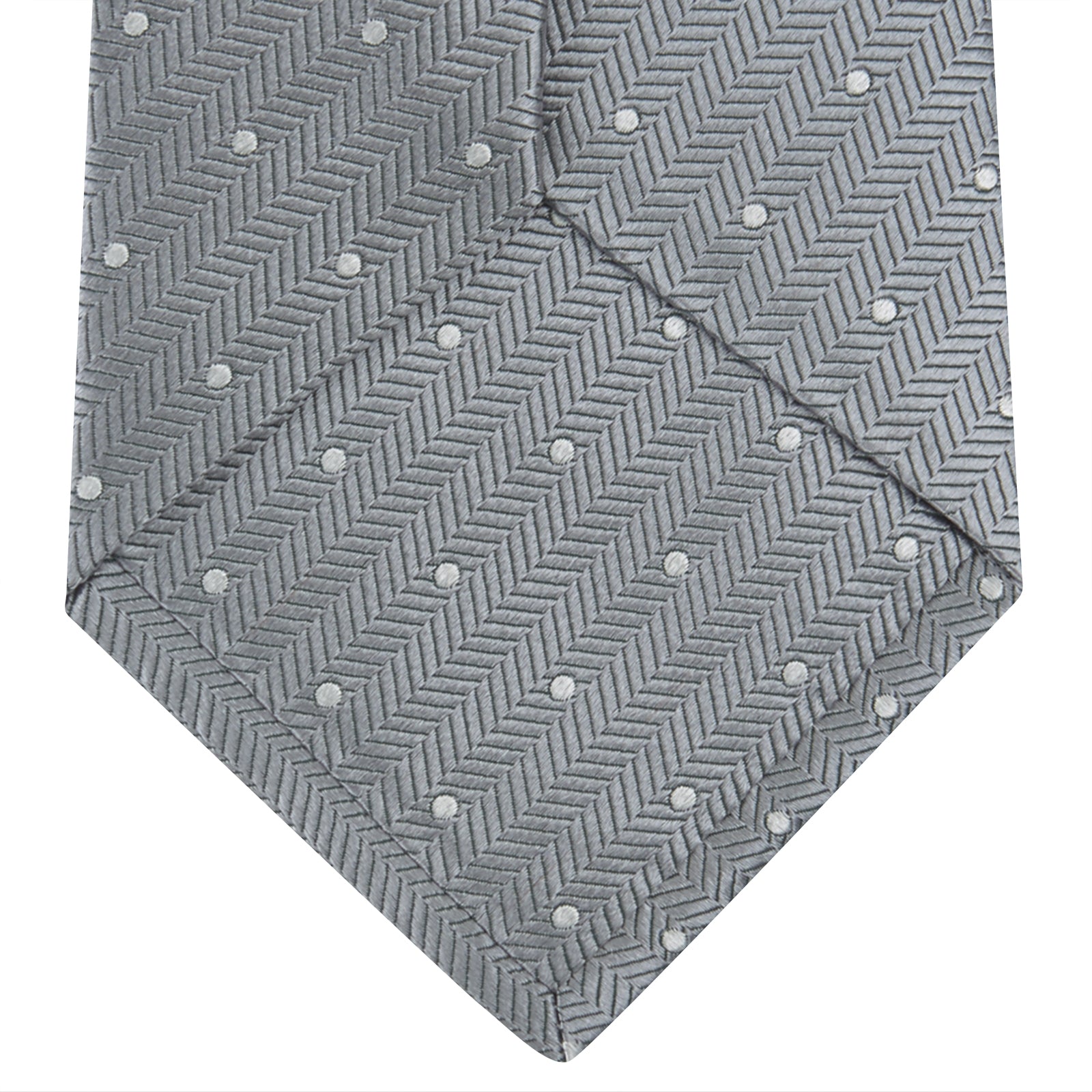 View 4 of product The Turnbull & Asser Grey and White Small Spot Herringbone Silk Tie, expertly woven from silk, is displayed rolled-up against a white background.