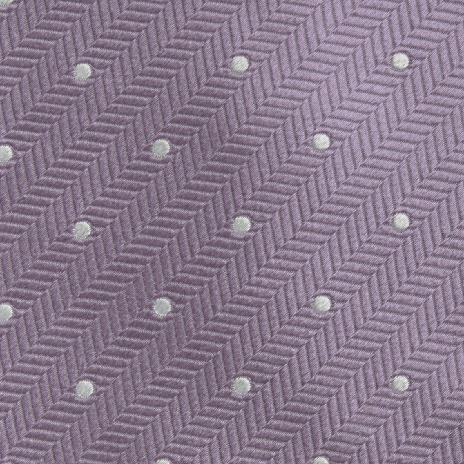 View 3 of product The Turnbull & Asser Lilac and White Small Spot Herringbone Silk Tie, crafted from fine English silk, is neatly rolled and displayed on a plain white background.