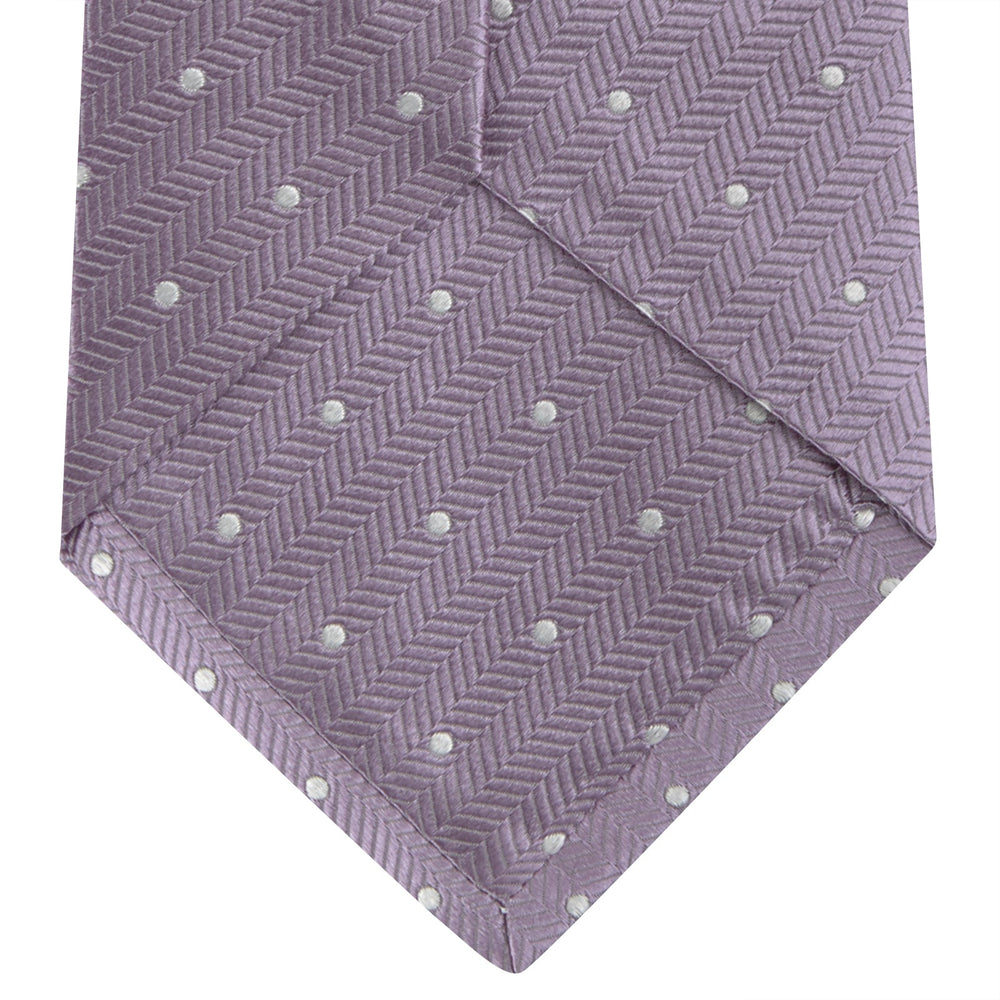 The Turnbull & Asser Lilac and White Small Spot Herringbone Silk Tie, crafted from fine English silk, is neatly rolled and displayed on a plain white background.