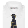 View 2 of product The Navy and Gold Striped Zigzag Silk Tie by Turnbull & Asser features a bold geometric pattern—an essential modern accessory shown rolled up with the pointed end forward on a white background.