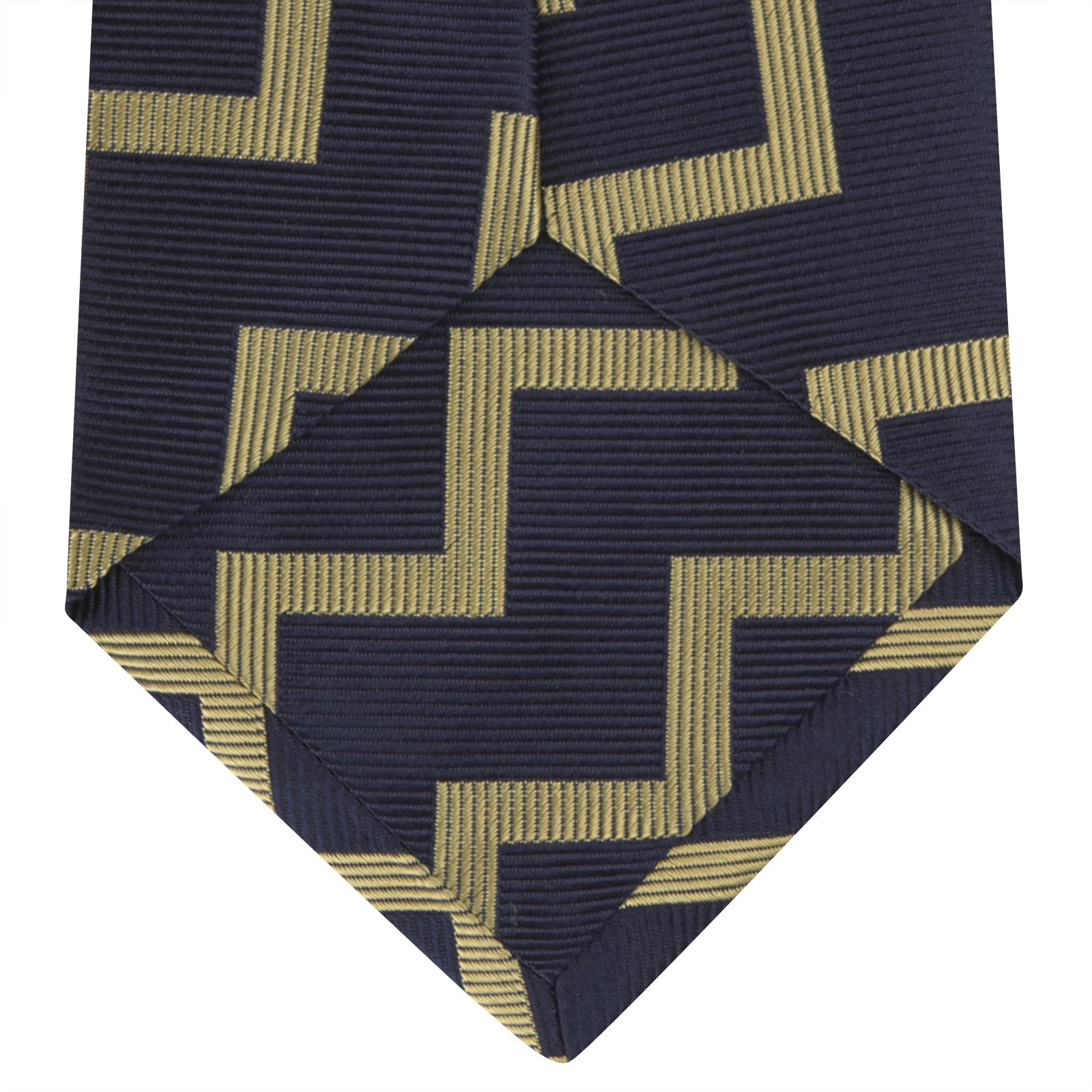 View 4 of product The Navy and Gold Striped Zigzag Silk Tie by Turnbull & Asser features a bold geometric pattern—an essential modern accessory shown rolled up with the pointed end forward on a white background.