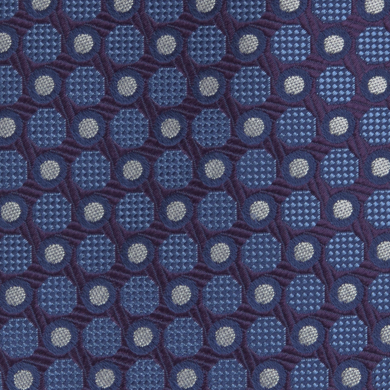 View 3 of product The Turnbull & Asser Plum and Blue Circle and Spot Silk Tie, shown rolled up on a white background, features a classic pattern—an elegant choice to complement any office shirt.