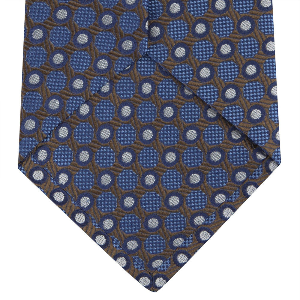 The Turnbull & Asser Brown and Blue Circle and Spot Silk Tie features a repeating pattern of brown and blue spots, ideal for office wear, shown on a white background.