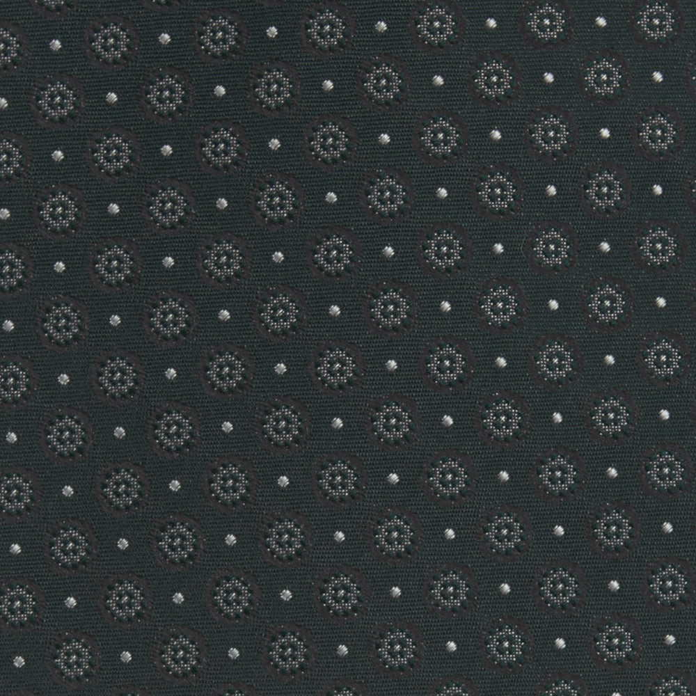 The Turnbull & Asser Forest Green Floral Spot Silk Tie features a subtle light gray circular pattern, shown rolled on a white background—a classic accessory ideal for office shirts.