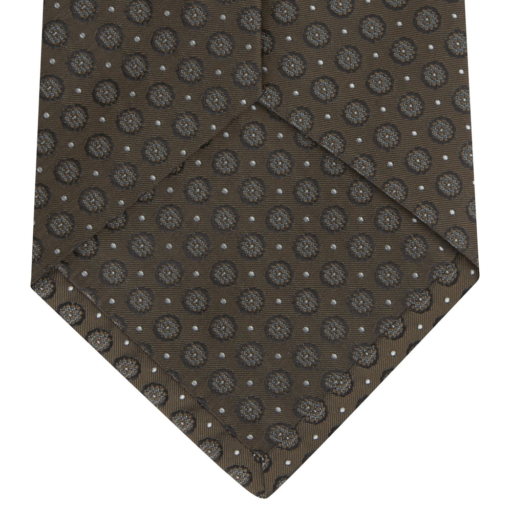The Brown Floral Spot Silk Tie by Turnbull & Asser features a classic brown base with silver-gray floral spots—an elegant accessory that pairs perfectly with your office shirts.