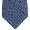 View 4 of product The Light Blue Floral Spot Silk Tie by Turnbull & Asser features a classic pattern in varied blue tones, rolled up on a white background—an ideal accessory to complement any office shirt.
