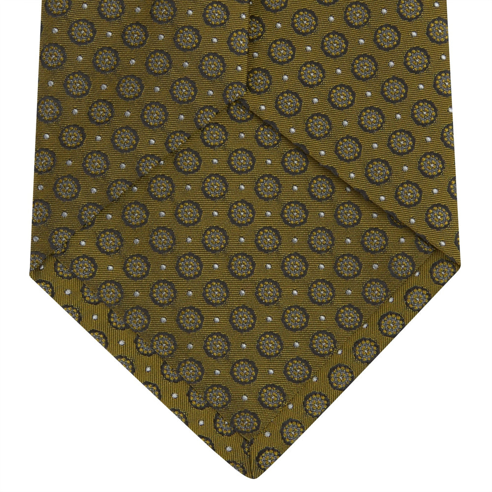 The Gold Floral Spot Silk Tie by Turnbull & Asser showcases a rolled-up design in olive green silk with light floral spots, perfect for adding a refined touch to any office shirt and standing out against a plain white background.