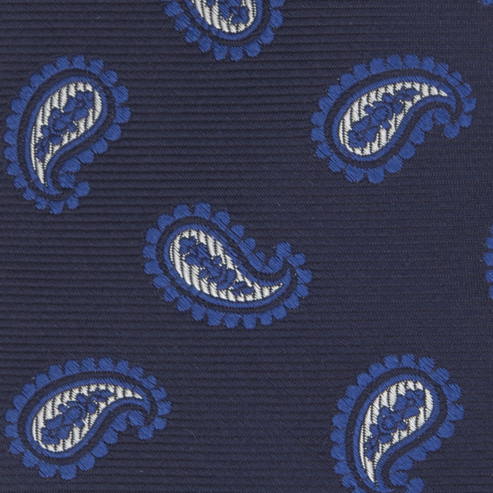 The Turnbull & Asser Navy and Royal Blue Floating Paisley Silk Tie features an elegant blue and white paisley pattern, styled in a rolled presentation on a plain white background.
