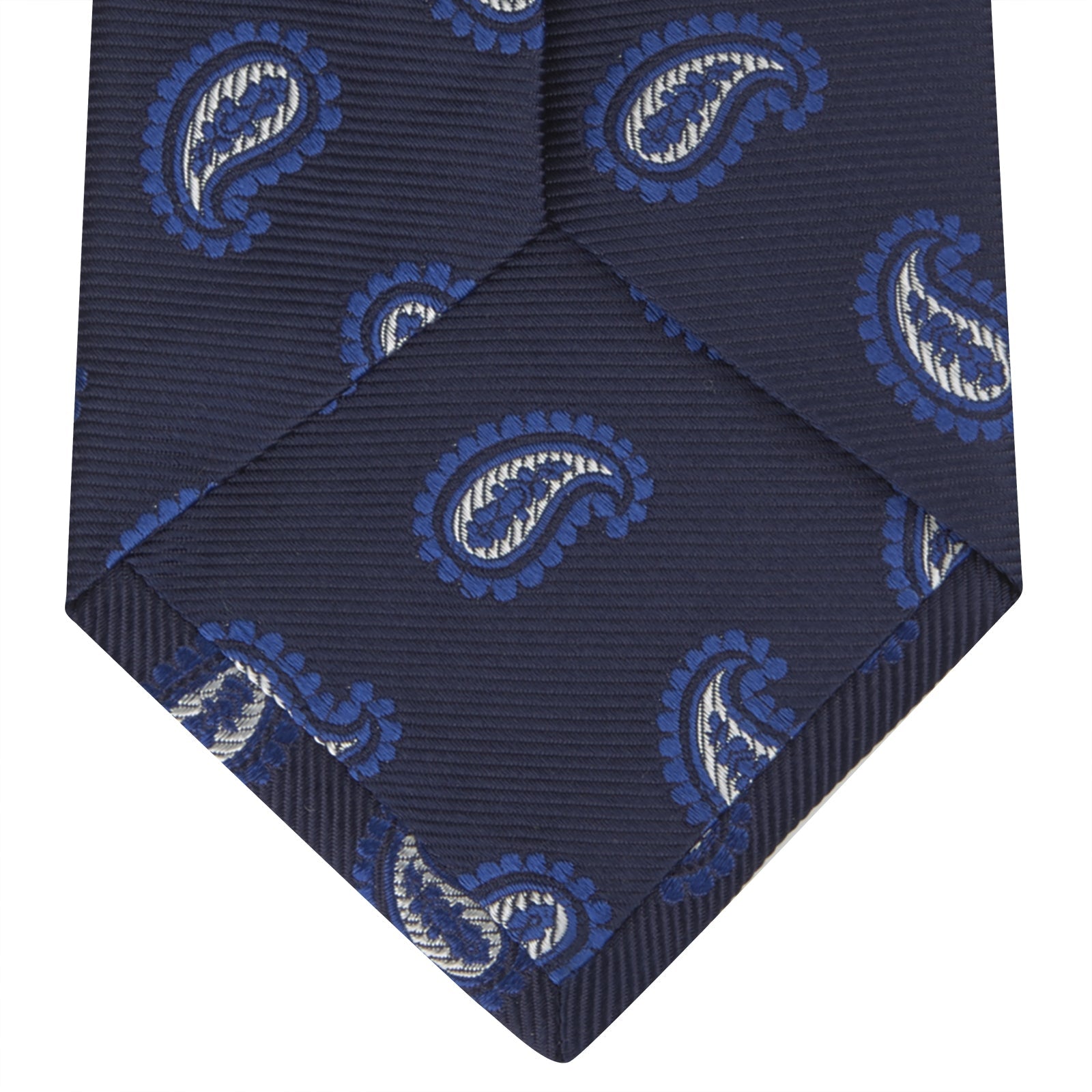 View 4 of product The Turnbull & Asser Navy and Royal Blue Floating Paisley Silk Tie features an elegant blue and white paisley pattern, styled in a rolled presentation on a plain white background.